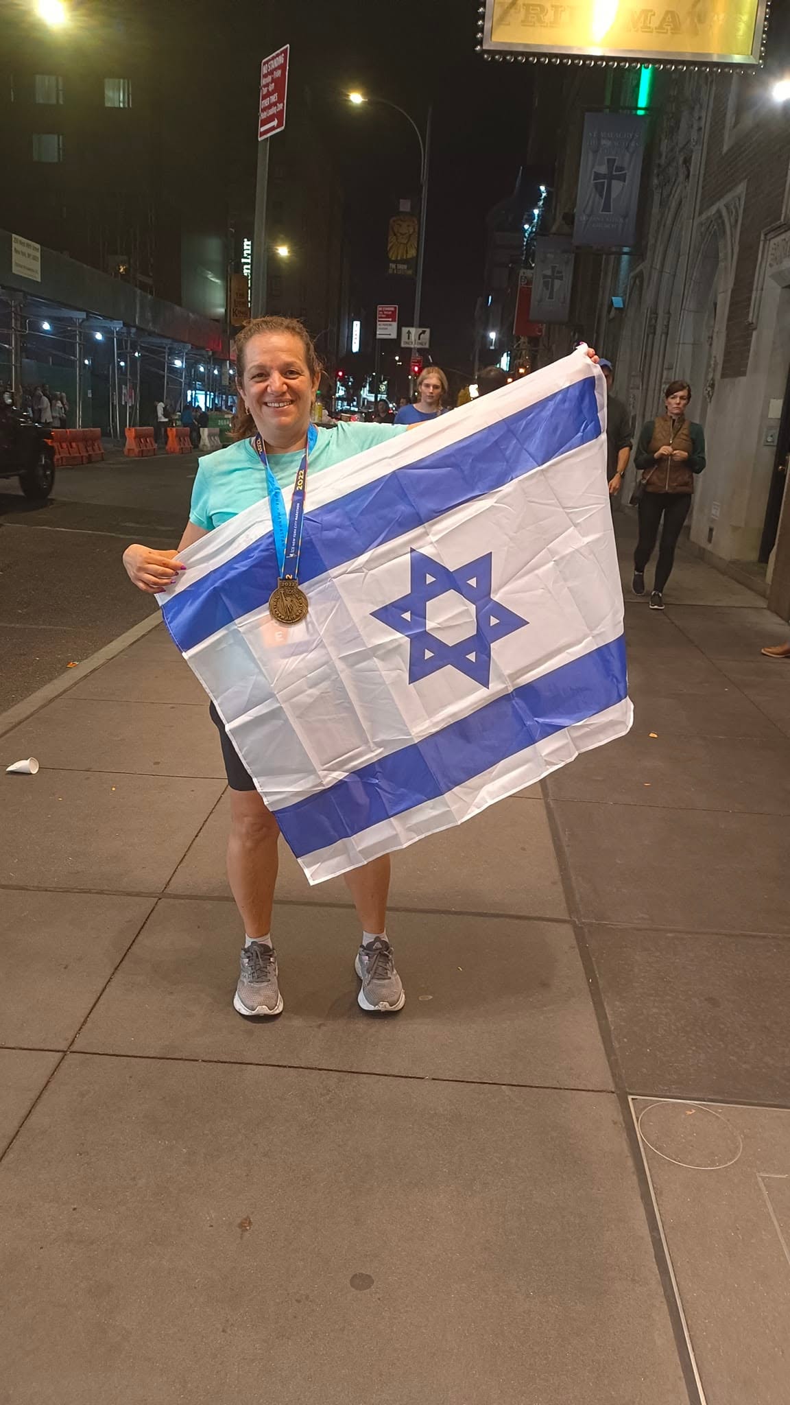 אתי עם דגל ישראל ומדליה אחרי מרתון ניו יורק